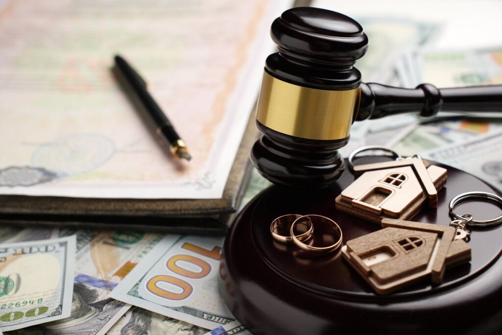 A gavel with wedding rings, and key chains on top of it